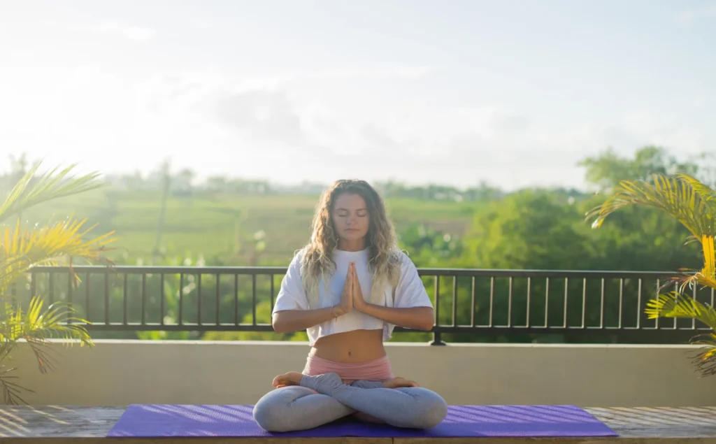 Woman practicing morning meditation for self-care routine.