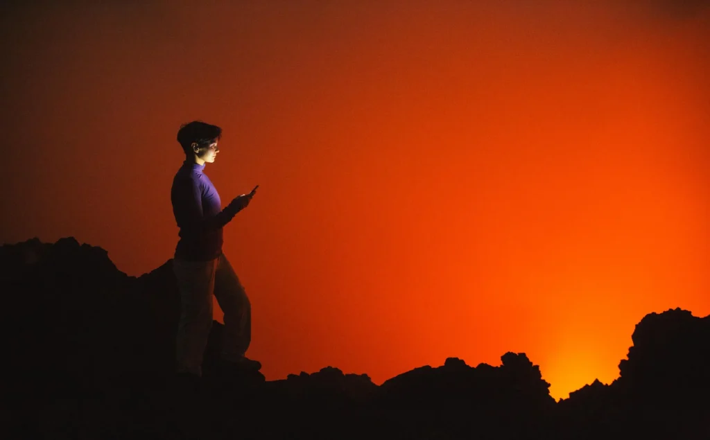 Person meditating near a dimmed smartphone in nature, representing mental health balance in the digital age.